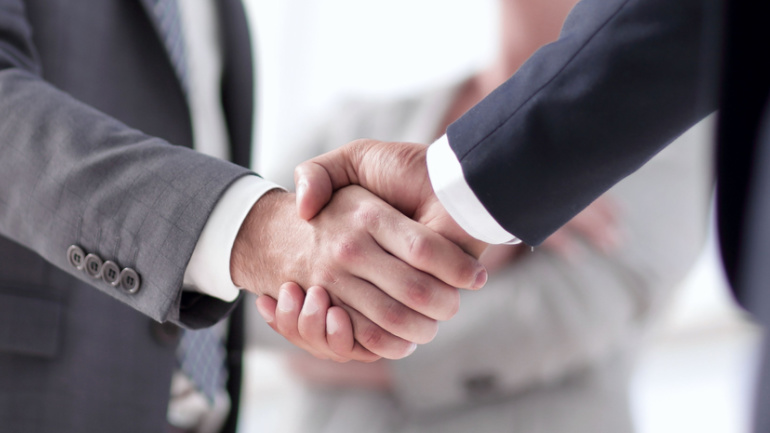 closeup of handshake of business partners Dish Network