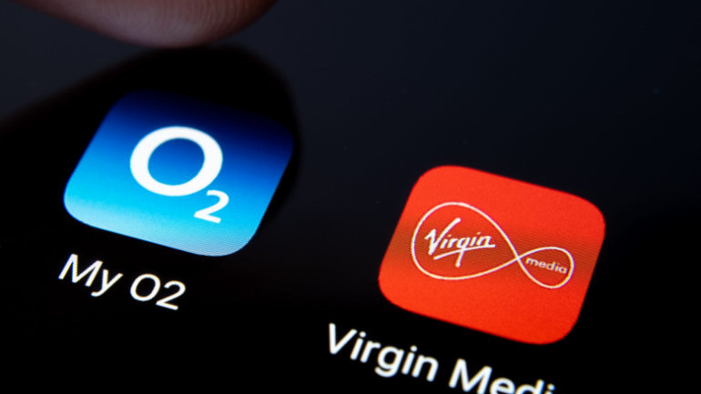 Virgin Media and My O2 apps on smartphone screen and finger pressing one of them. Macro. Concept for potential merger of the two telecom companies.