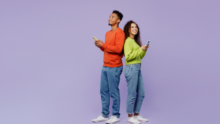 Full body side view young couple two friends family man woman of African American ethnicity wear casual clothes together hold use mobile cell phone look overhead isolated on plain purple background Week #44